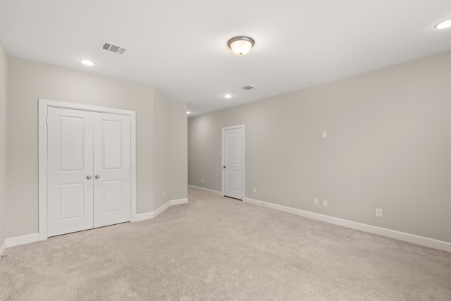 unfurnished room featuring light carpet