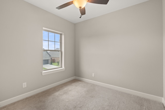 carpeted spare room featuring ceiling fan