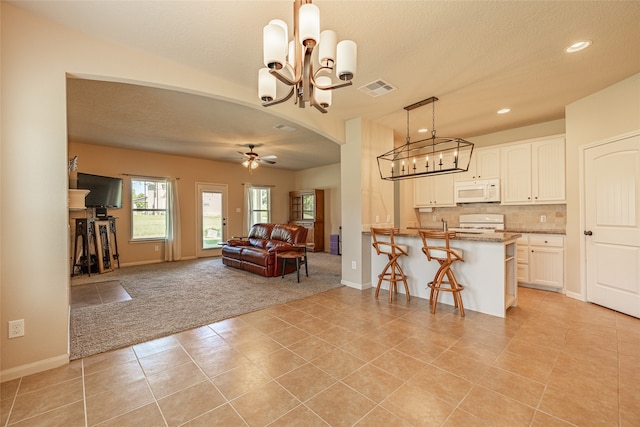 interior space with ceiling fan with notable chandelier