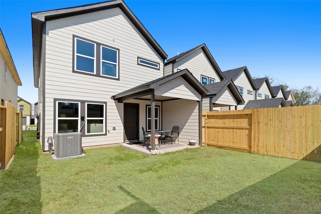 back of house with a lawn, cooling unit, and a patio