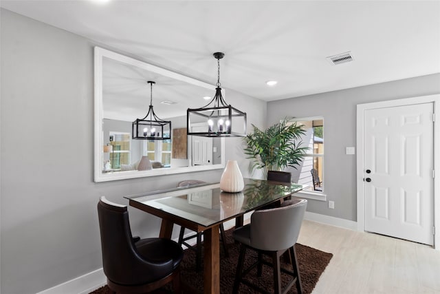 dining area featuring light hardwood / wood-style flooring and a notable chandelier