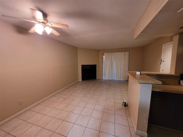 unfurnished living room with ceiling fan and light tile patterned floors