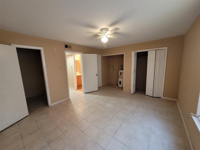 unfurnished bedroom featuring light tile patterned floors, ceiling fan, and ensuite bathroom