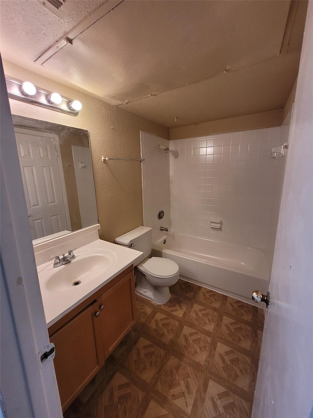 full bathroom featuring parquet flooring, a textured ceiling, toilet, tiled shower / bath, and vanity