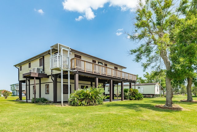 rear view of house featuring a wooden deck and a yard