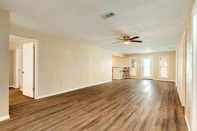 unfurnished living room with ceiling fan, a textured ceiling, and hardwood / wood-style flooring