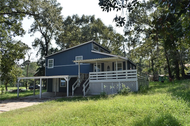 farmhouse-style home featuring covered porch, a carport, and a front yard