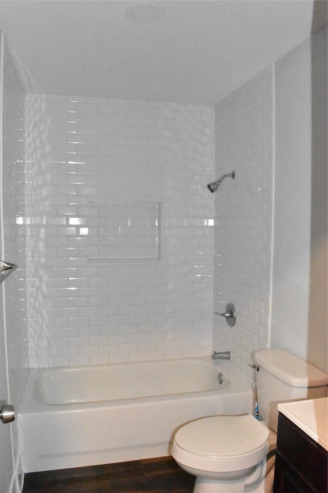 full bathroom with tiled shower / bath combo, vanity, and toilet