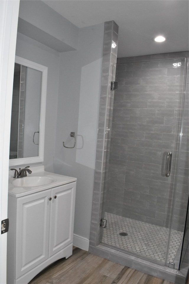 bathroom featuring an enclosed shower, vanity, and hardwood / wood-style floors