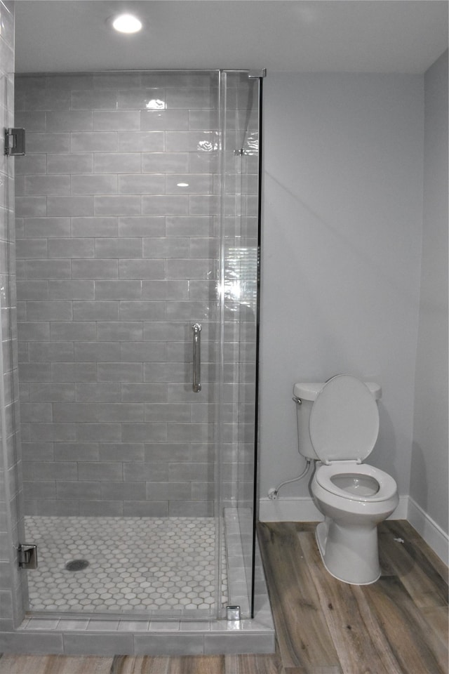 bathroom featuring toilet, hardwood / wood-style floors, and an enclosed shower