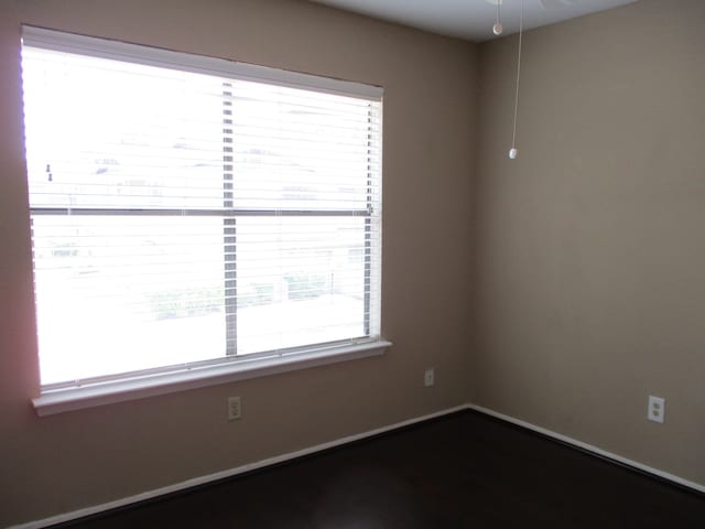 empty room featuring a wealth of natural light and ceiling fan