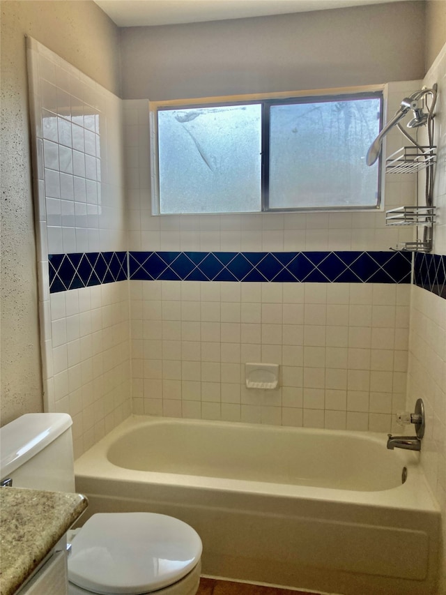 full bathroom with vanity, tiled shower / bath combo, and toilet