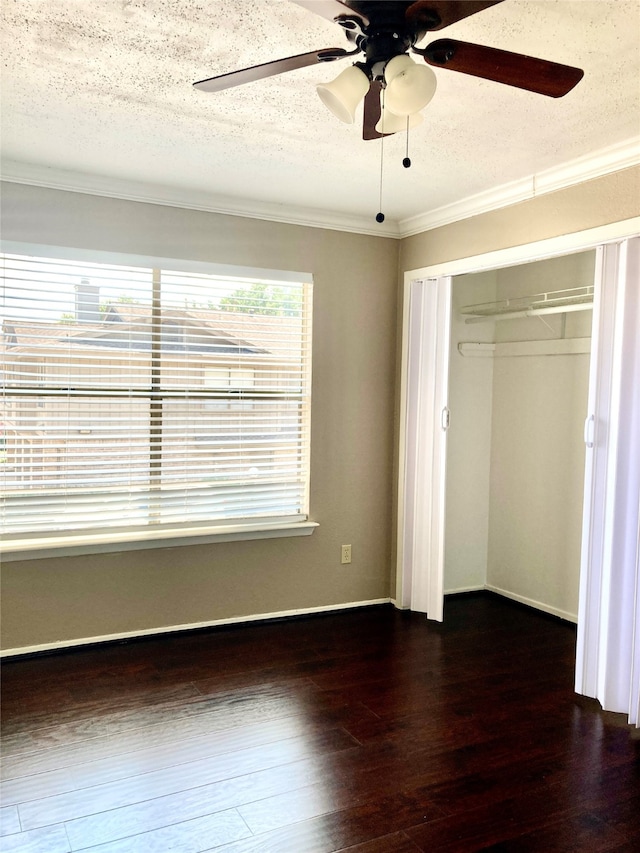 unfurnished bedroom with ornamental molding, a textured ceiling, ceiling fan, dark hardwood / wood-style floors, and a closet