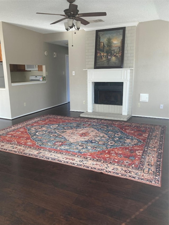 living room with a brick fireplace, a textured ceiling, ceiling fan, hardwood / wood-style floors, and lofted ceiling