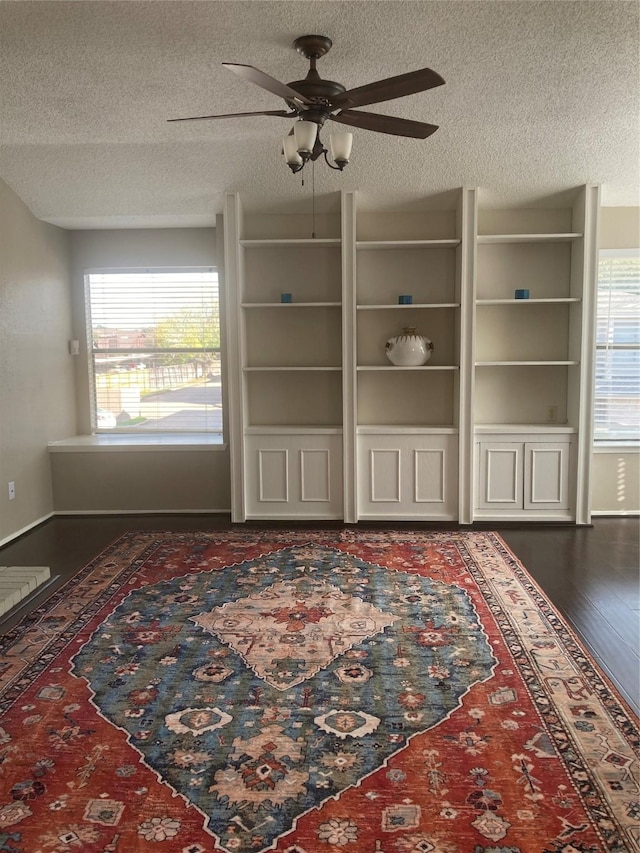 unfurnished living room featuring a textured ceiling, plenty of natural light, and ceiling fan