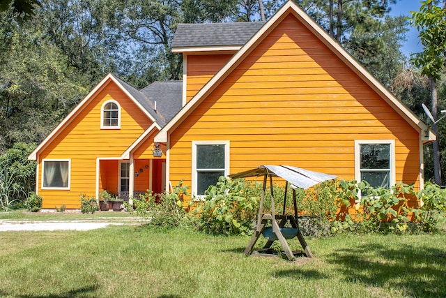 rear view of property with a lawn