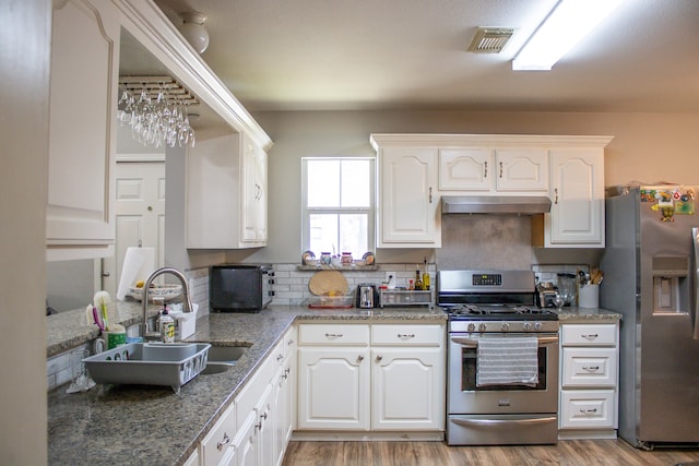 kitchen with light wood-type flooring, stainless steel appliances, sink, and white cabinetry