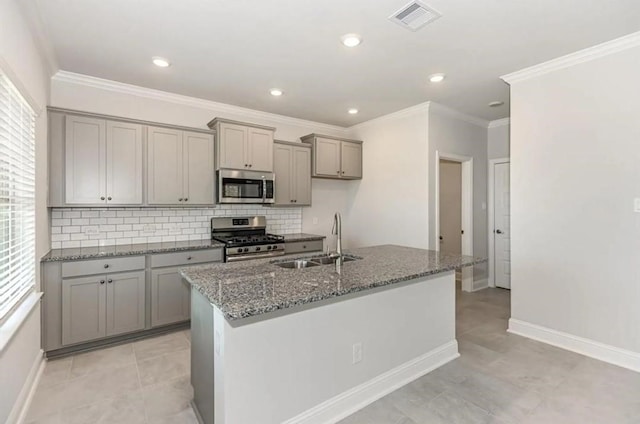 kitchen featuring a kitchen island with sink, light tile patterned flooring, gray cabinets, stainless steel appliances, and sink