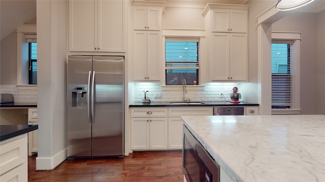 kitchen with built in microwave, dark hardwood / wood-style flooring, sink, decorative backsplash, and stainless steel refrigerator with ice dispenser