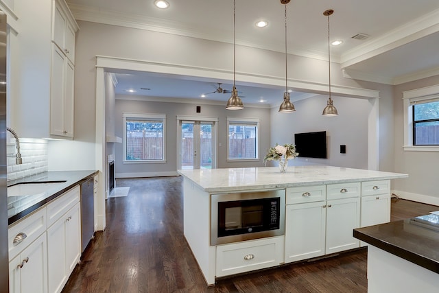 kitchen featuring dark hardwood / wood-style floors, stainless steel dishwasher, white cabinets, and black microwave