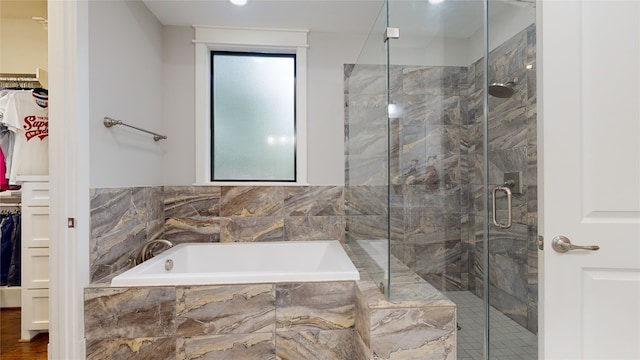 bathroom featuring wood-type flooring and separate shower and tub