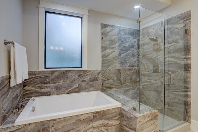 bathroom featuring separate shower and tub and plenty of natural light