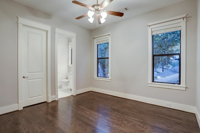 unfurnished bedroom featuring dark hardwood / wood-style floors, ceiling fan, and ensuite bathroom