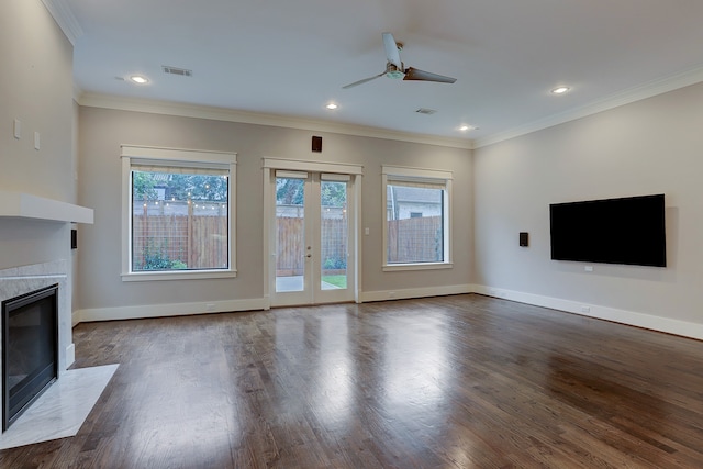 unfurnished living room featuring hardwood / wood-style floors, crown molding, a high end fireplace, and ceiling fan