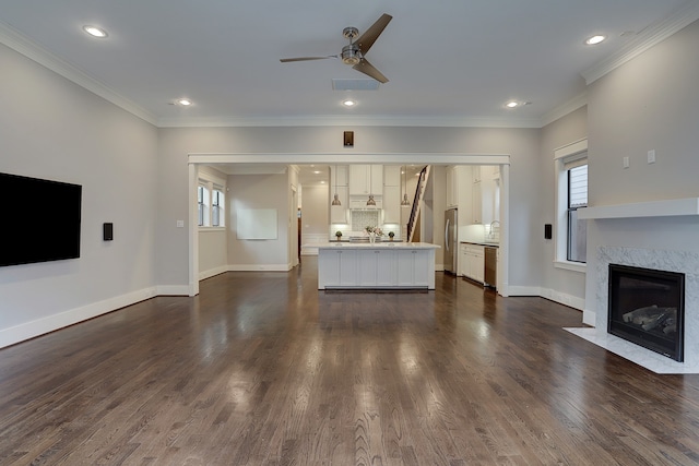 unfurnished living room featuring a fireplace, dark wood-type flooring, and crown molding