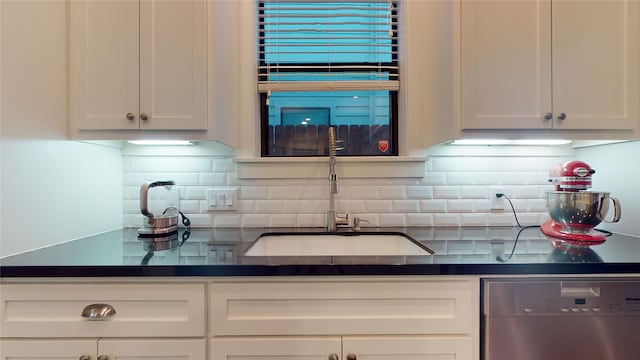 kitchen featuring decorative backsplash, white cabinets, and stainless steel dishwasher