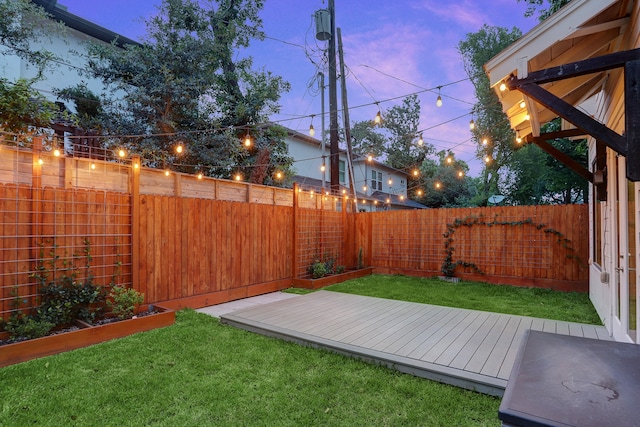 yard at dusk featuring a deck