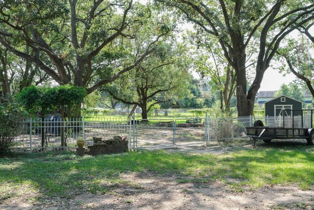 view of yard with a gate, fence, and an outbuilding