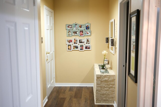 hall featuring dark wood-style floors and baseboards