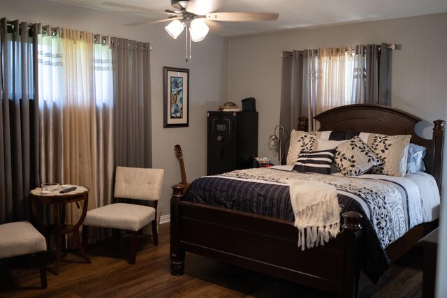 bedroom with a ceiling fan and dark wood-style flooring