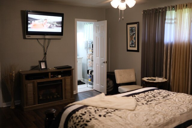 bedroom with dark wood-style floors and connected bathroom