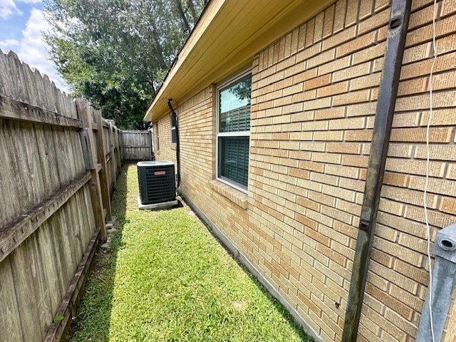 view of side of property featuring a yard and cooling unit