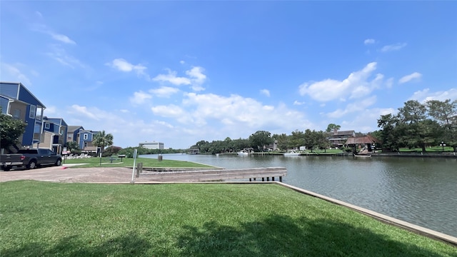 view of property's community with a lawn and a water view