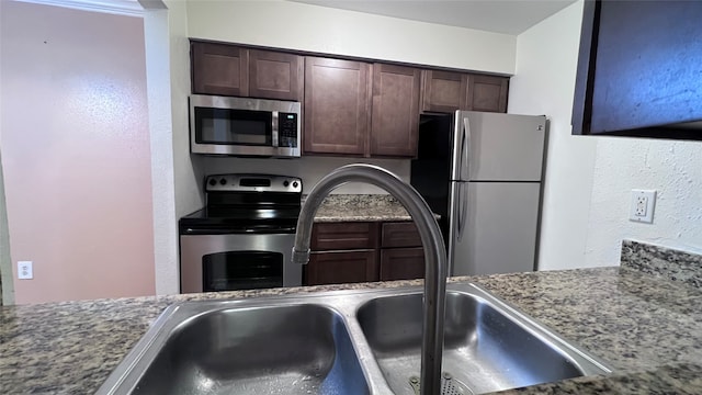 kitchen featuring sink, stainless steel appliances, and dark brown cabinetry