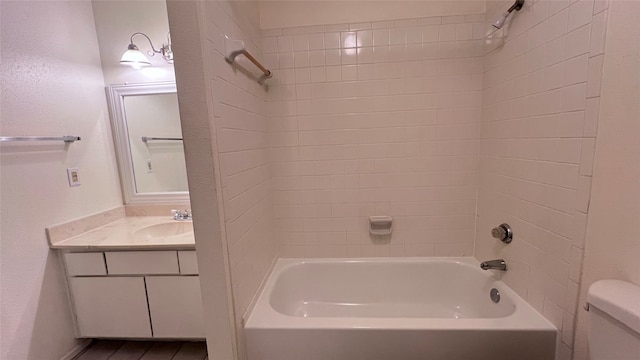 full bathroom featuring toilet, tiled shower / bath combo, and vanity