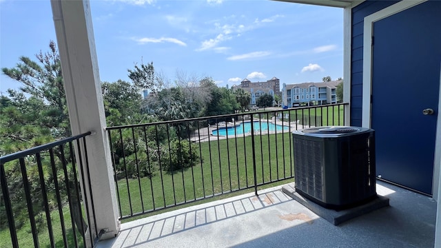 balcony featuring central AC unit and a fenced in pool