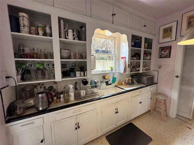 bar with white cabinetry and tasteful backsplash