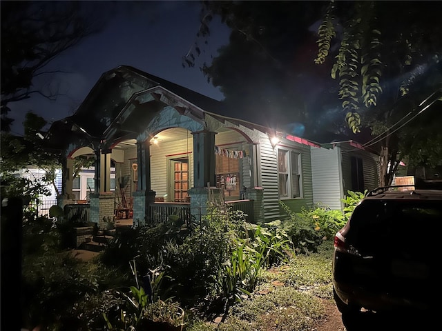 property exterior at twilight with covered porch