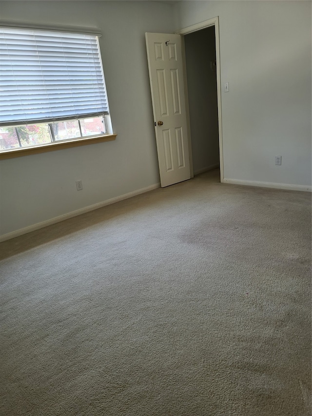 spare room featuring light colored carpet