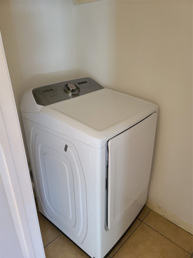 laundry room with light tile patterned floors and washer / dryer