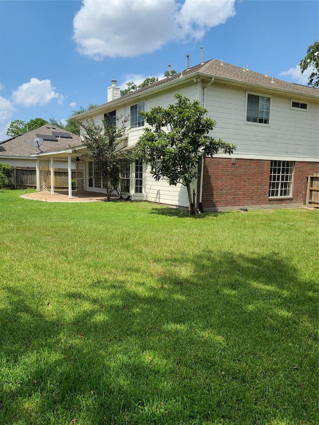 rear view of property with a yard