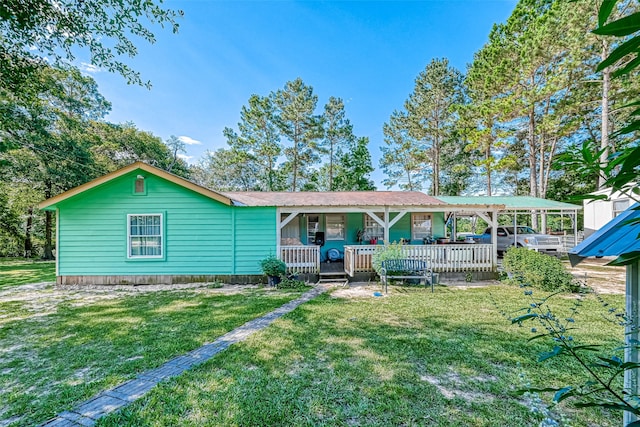 back of house featuring covered porch and a lawn