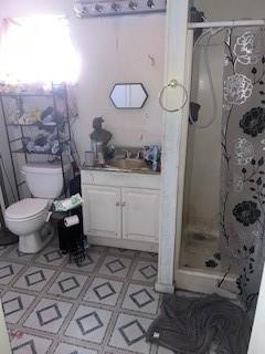 bathroom featuring a shower with curtain, tile patterned floors, vanity, and toilet