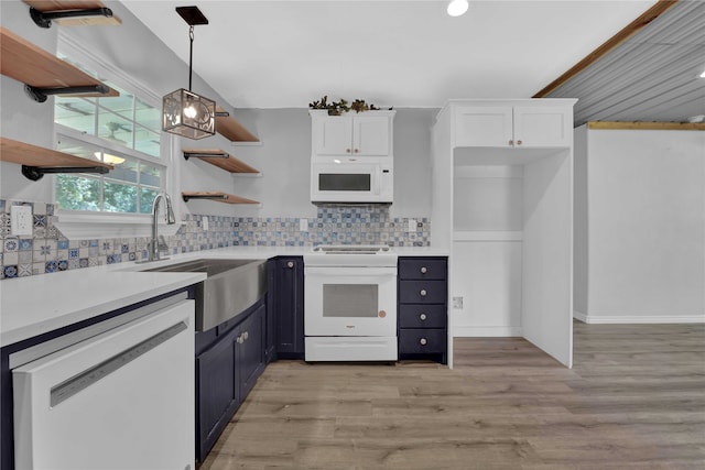 kitchen featuring backsplash, light hardwood / wood-style flooring, white appliances, and decorative light fixtures