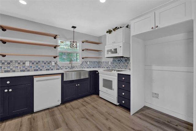 kitchen with white appliances, pendant lighting, light hardwood / wood-style floors, sink, and decorative backsplash