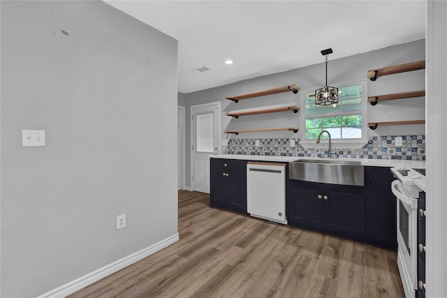 kitchen with decorative backsplash, white appliances, pendant lighting, and light hardwood / wood-style floors